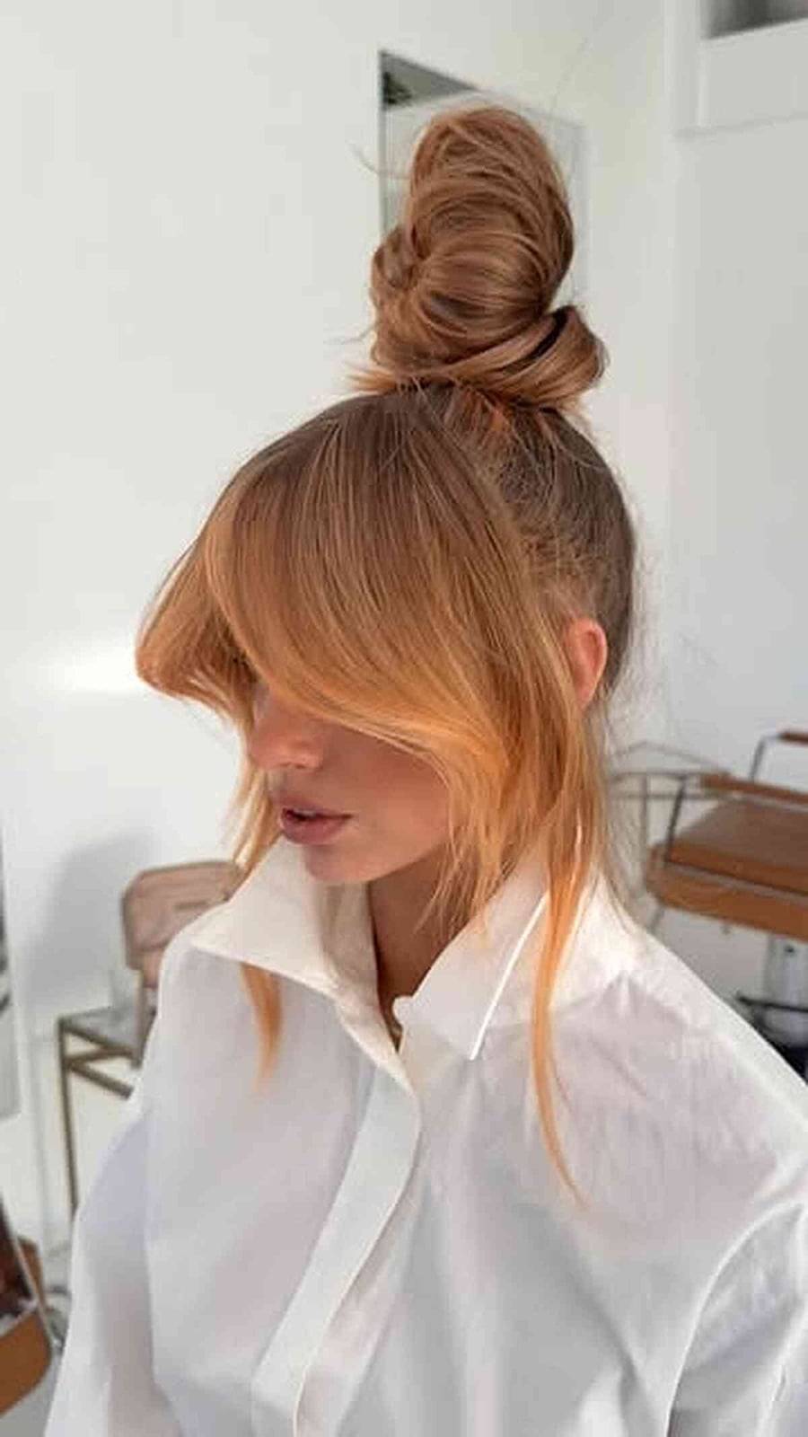 Loose Honey Blonde Balayage Bun With Curtain Bangs — Trendy High Bun Hairstyles