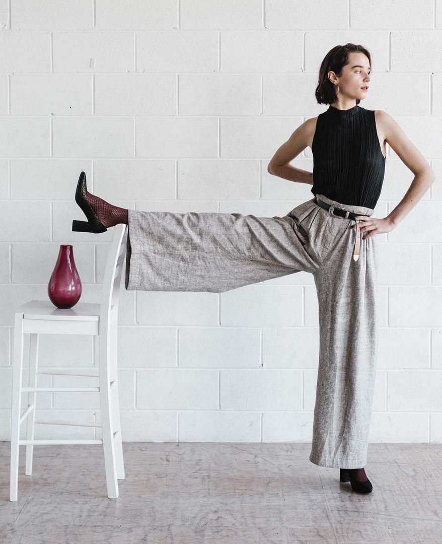 Black Sleeveless Top with Grey Wide-Leg Trousers and Fishnet Tights — Trendy Professional Outfits
