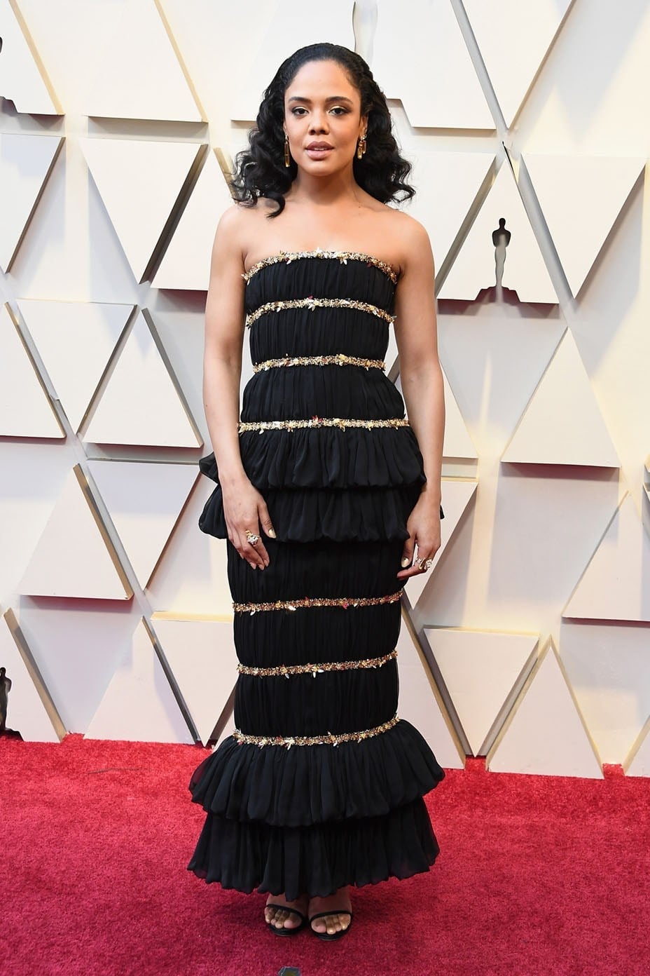 Black Strapless Gown with Tiered Ruffles and Gold Trim — Trendy Red Carpet Outfits