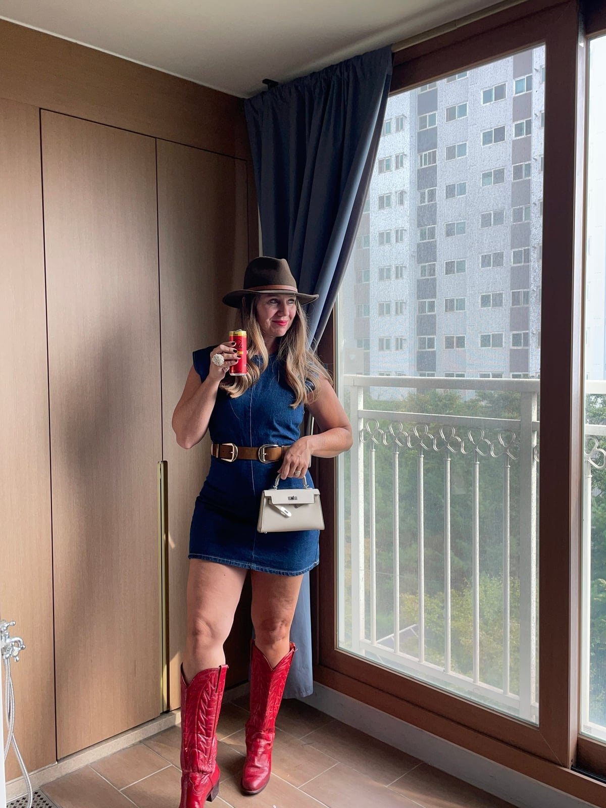 Red Cowboy Boots With Denim Dress and Fedora — Trendy Red Cowboy Boots Outfit