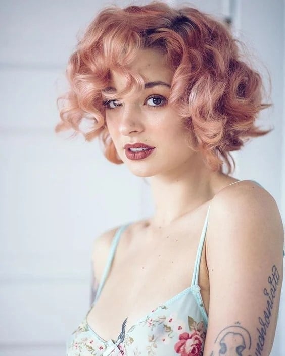 Chin Length Bob With Rose Gold Curls and Curtain Bangs — Trendy Rose Gold Hair
