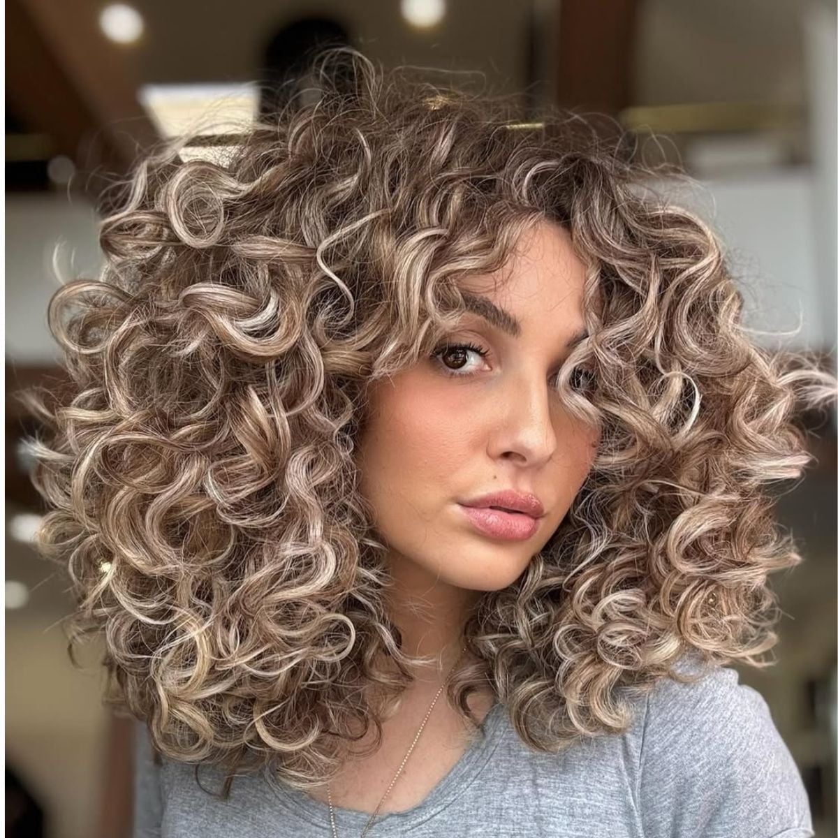Collarbone Layers With Curtain Bangs And Blonde Highlights — Trendy Shoulder Length Curly Hair