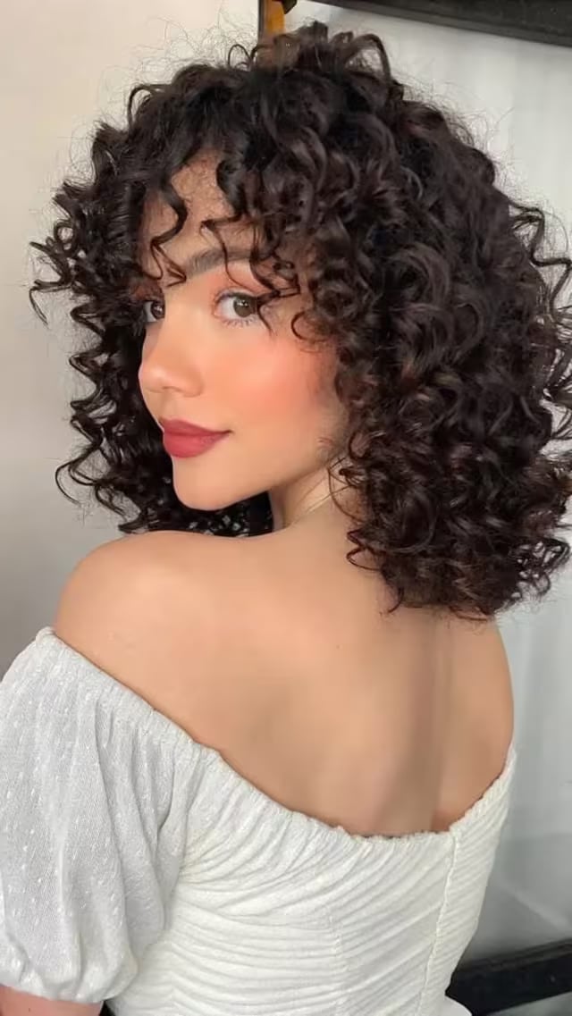 Layered Bob With Curtain Bangs At Collarbone — Trendy Shoulder Length Curly Hair