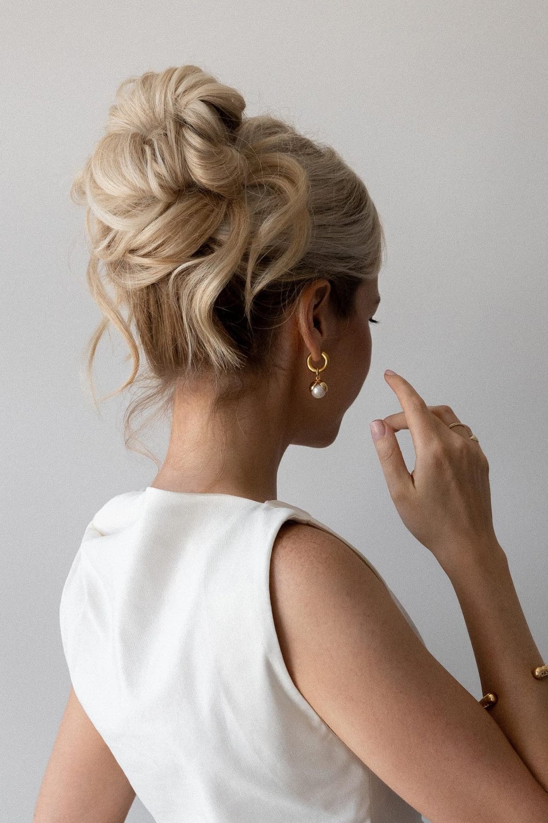 Blonde Voluminous Textured High Bun With Face-Framing Pieces Blonde Voluminous Textured High Bun With Face-Framing Pieces — Trendy Wedding Guest Updos