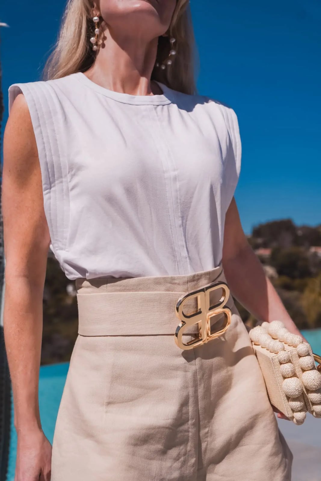 Sleeveless White Tee With Beige Skirt And Logo Belt — Trendy White Tee Outfits