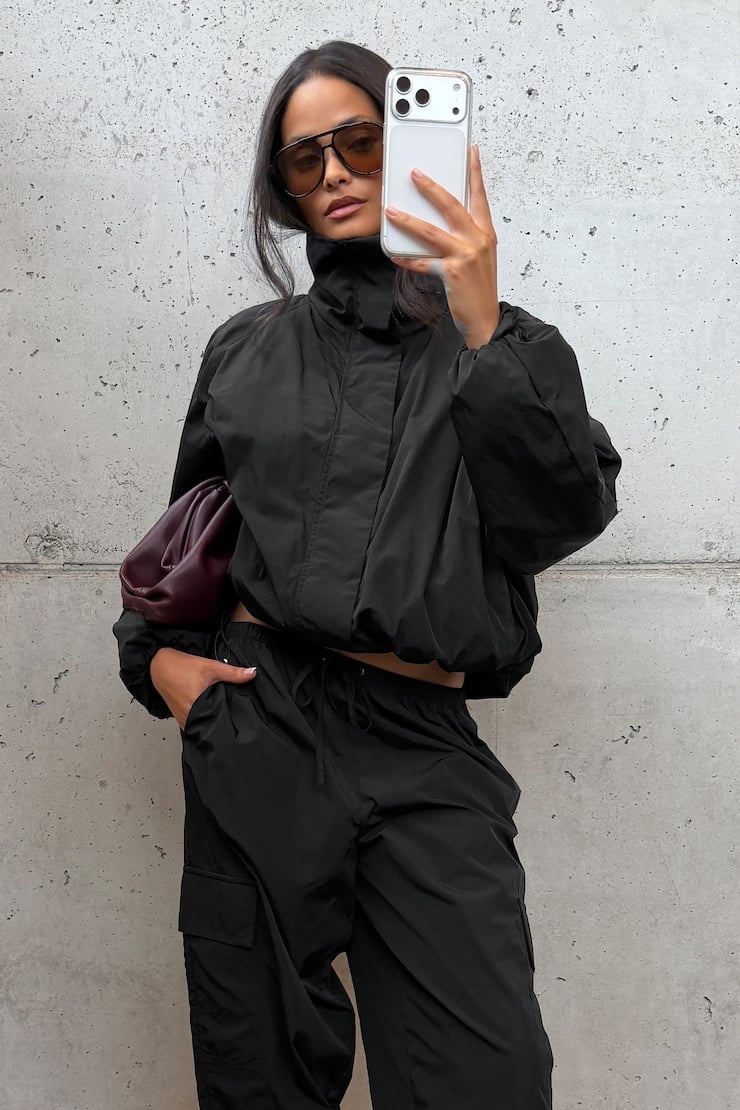 Black Cropped Windbreaker with Cargo Pants and Burgundy Clutch Bag — Trendy Windbreaker Outfits