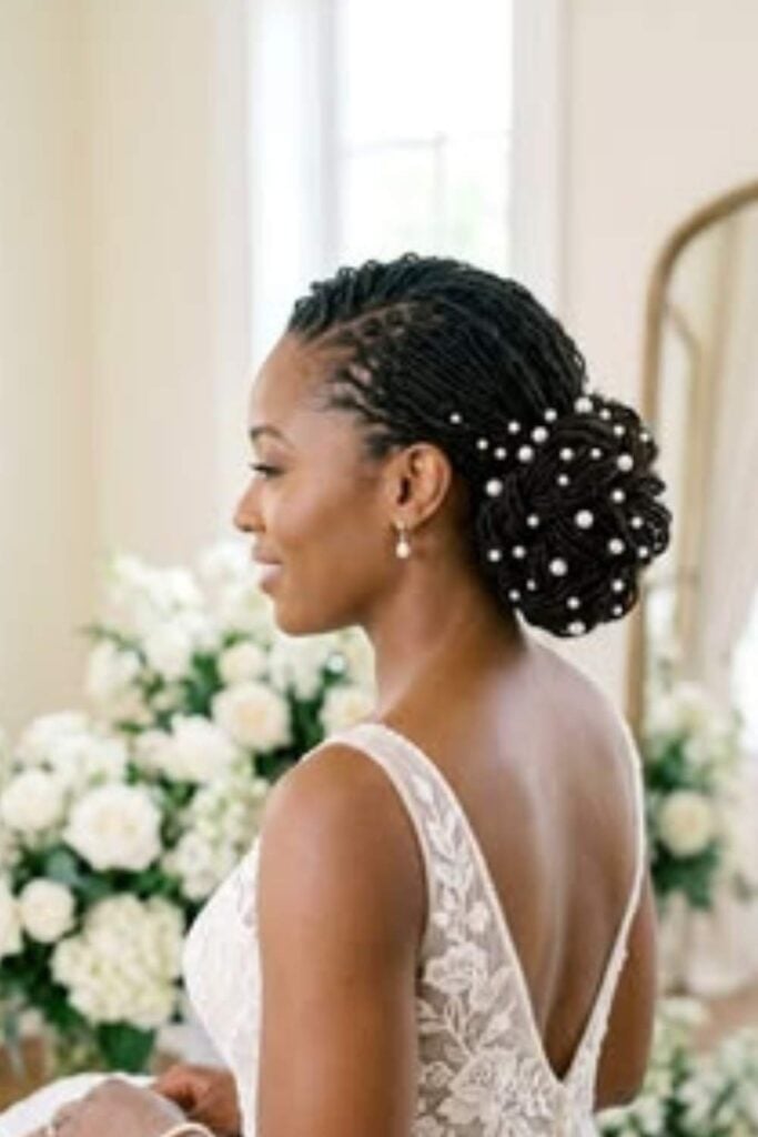 Intricate Black Bun With Pearl Embellishments Intricate Black Bun With Pearl Embellishments — Wedding Bun Ideas