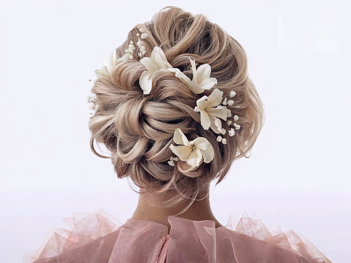 Woven Blonde Bun With Floral Accents Woven Blonde Bun With Floral Accents — Wedding Bun Ideas