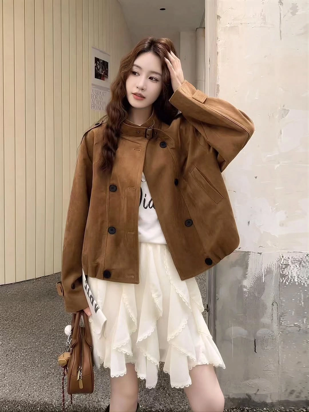 Short caramel brown buttoned jacket with white tiered skirt and brown handbag