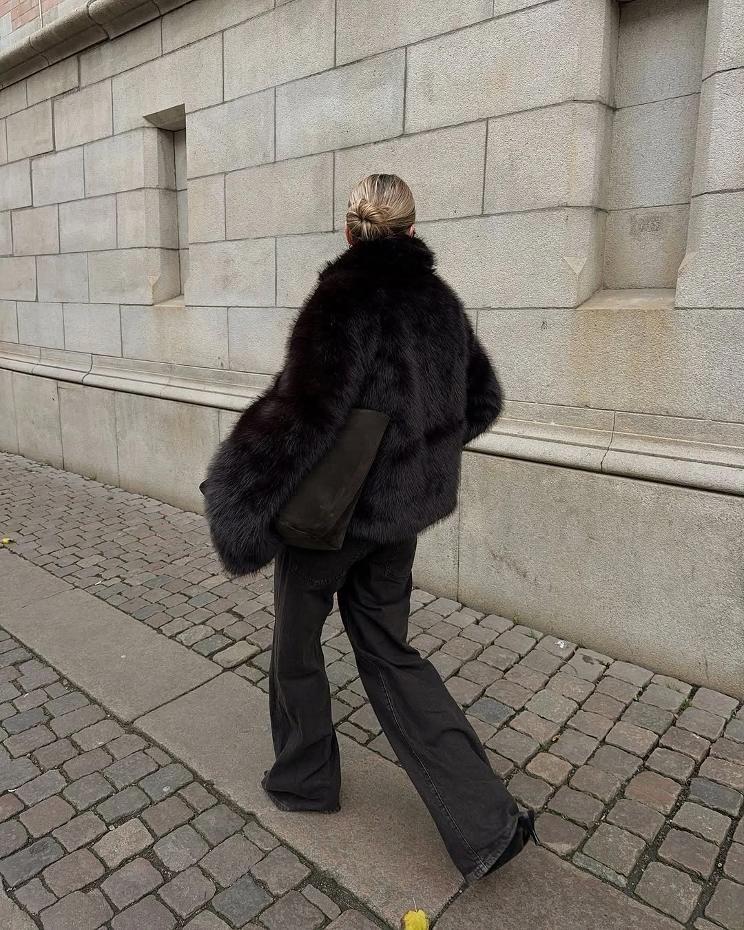 Oversized dark plush jacket with wide charcoal trousers and shoulder bag
