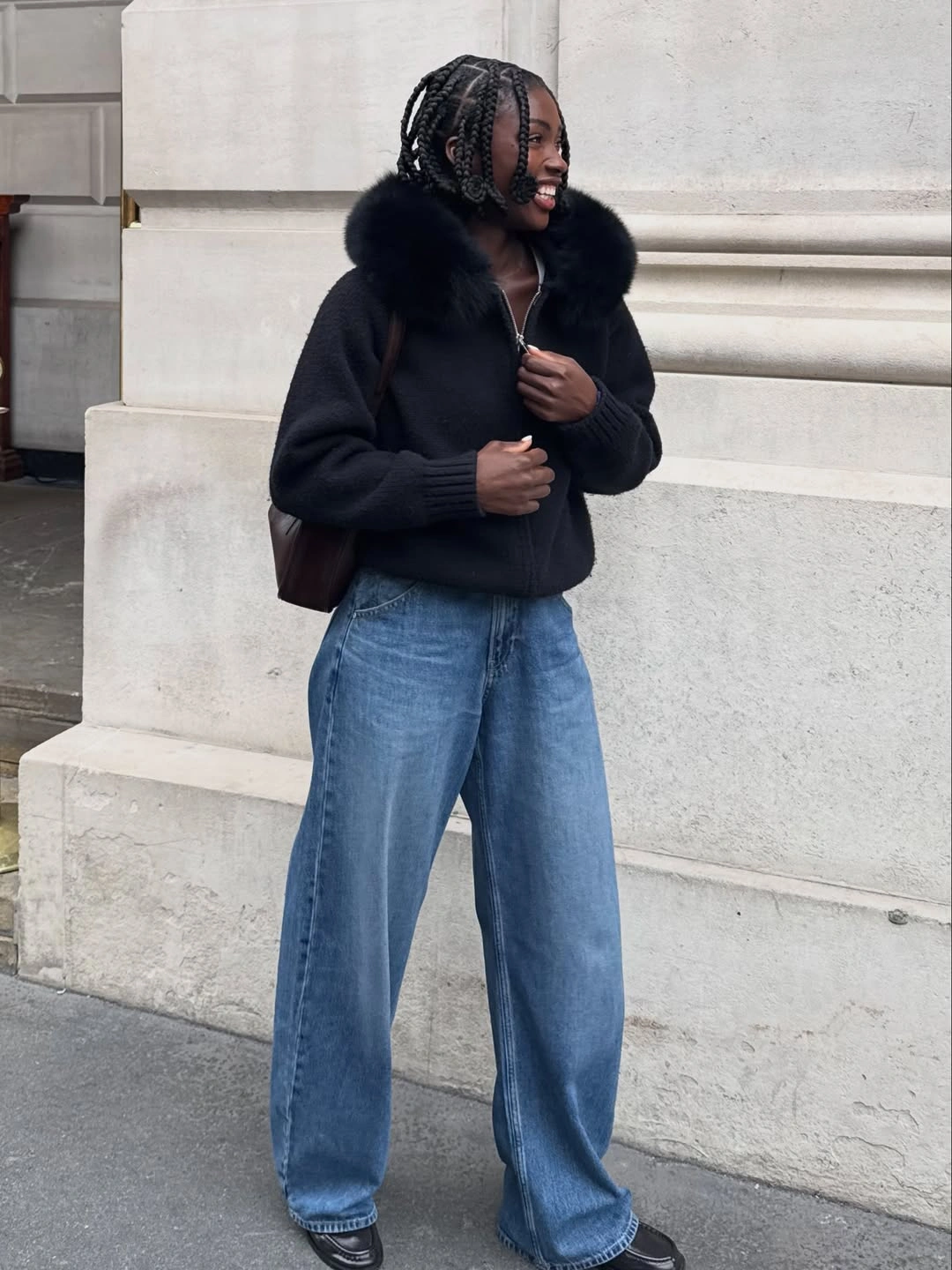 Black zip jacket with oversized collar, wide blue jeans and dark shoes