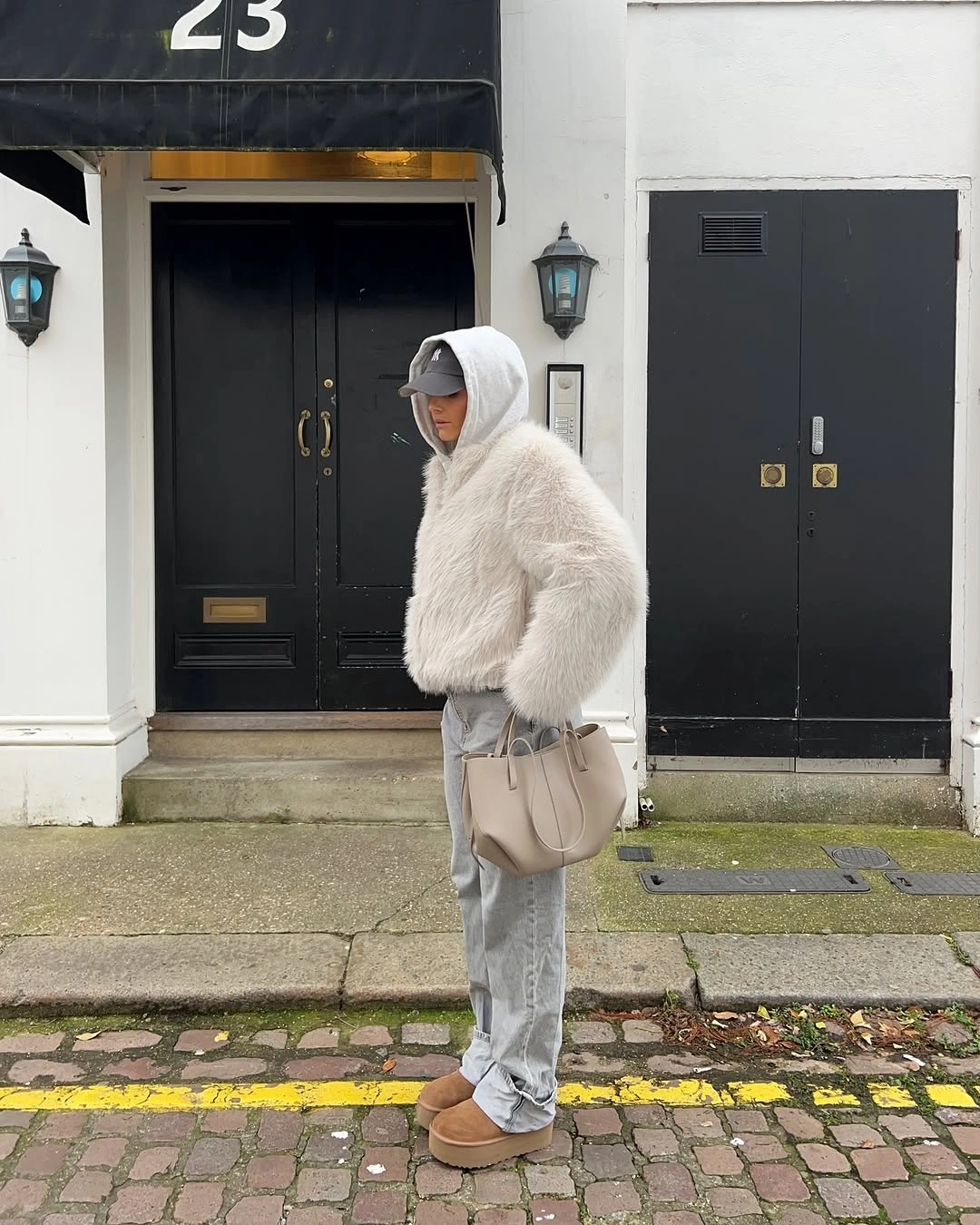 Oversized ivory jacket with gray hoodie, baseball cap and loose jeans