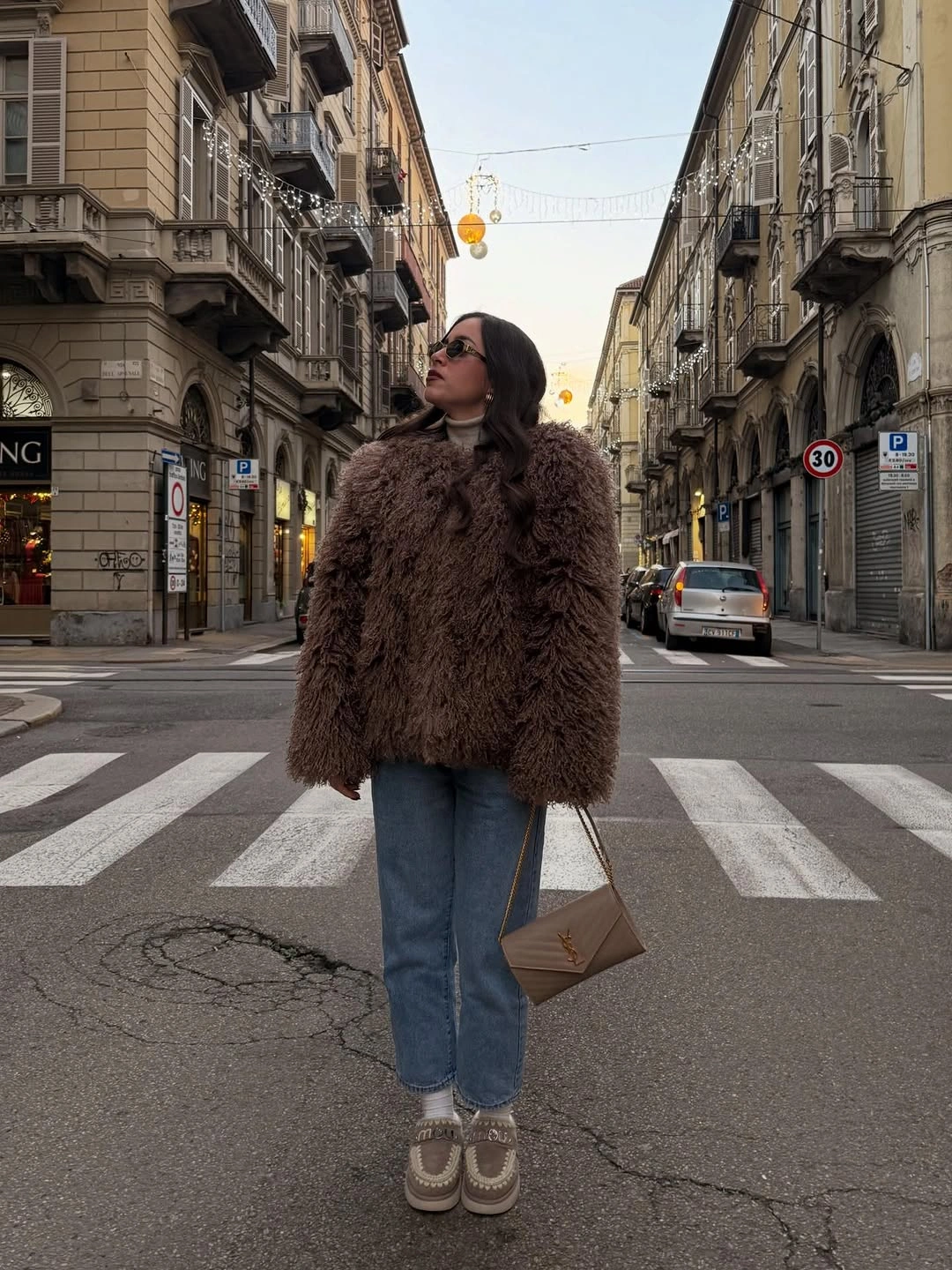 Cropped shaggy brown jacket, blue jeans, tan shoes, and crossbody bag