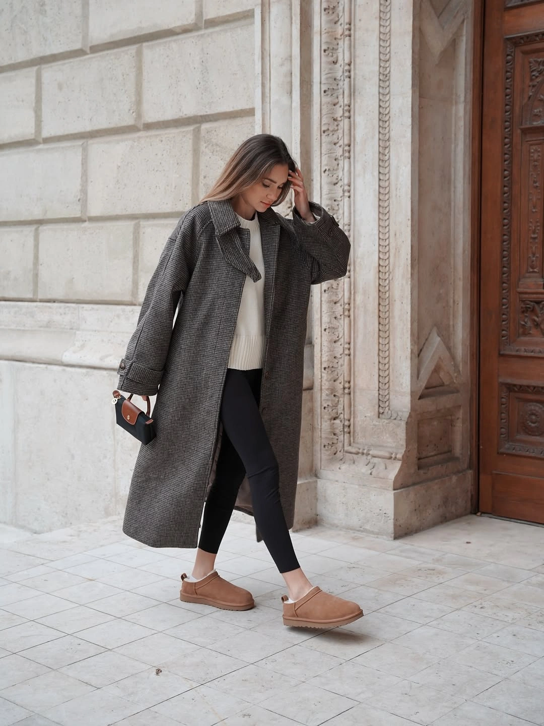 Long charcoal checked coat with black leggings and tan slip-ons